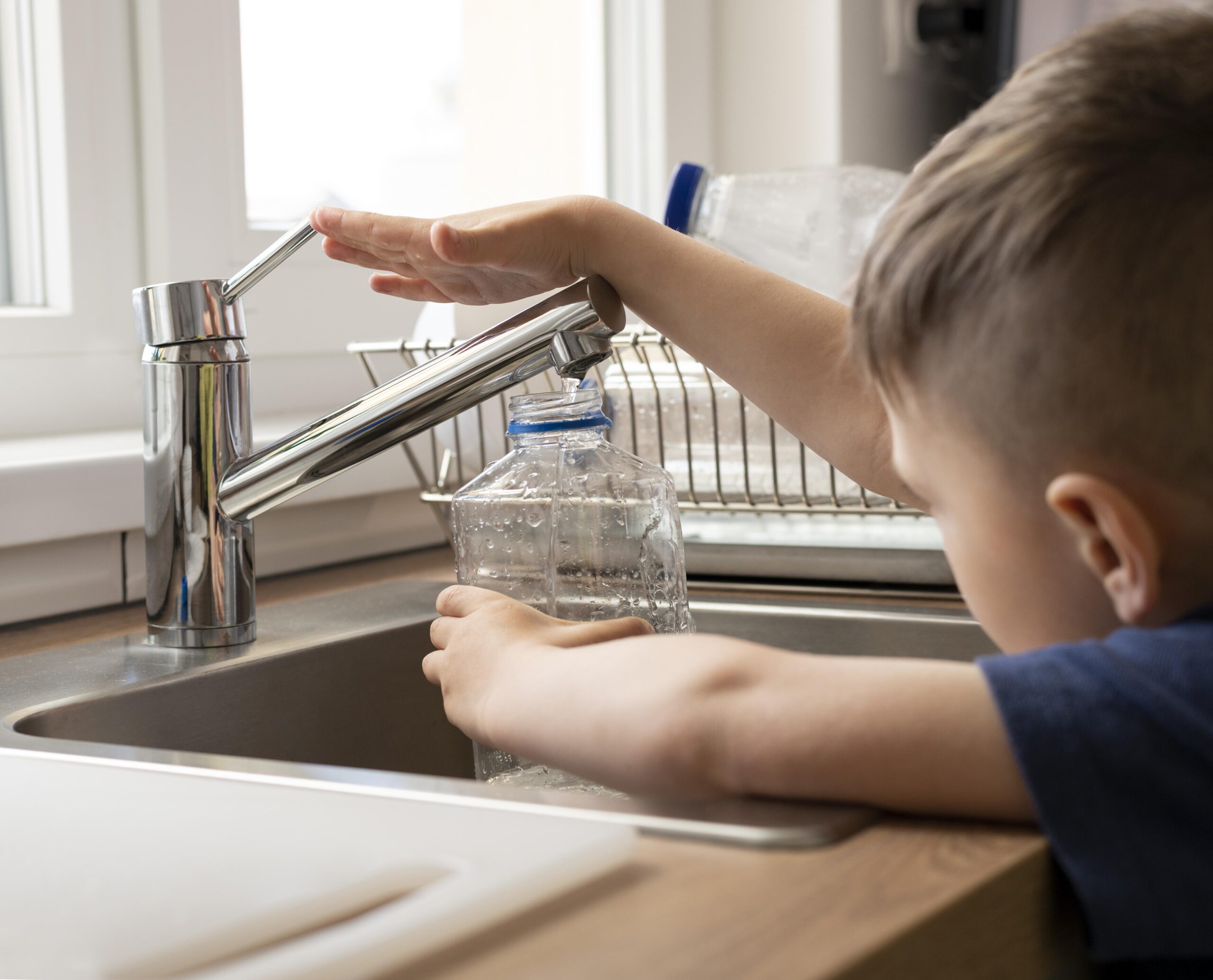 close-up-kid-filling-bottle-with-water-água-torneira-potável-sanepar