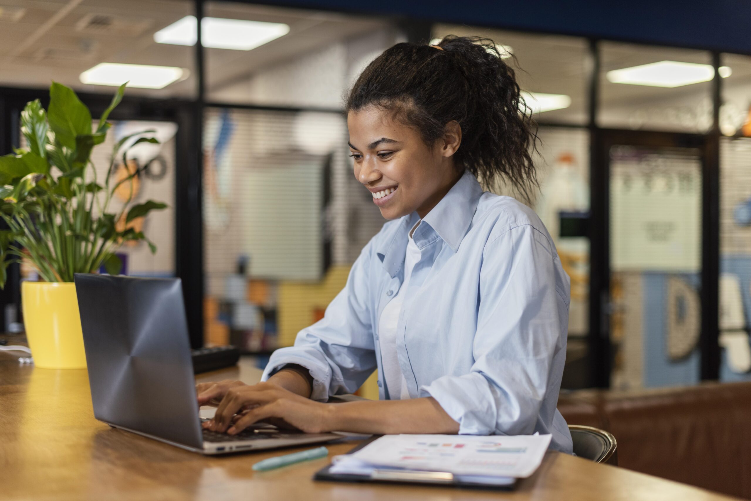 side-view-smiley-woman-working-with-laptop-office-o-que-é-lazy-job-geração-z