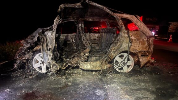 Carro pega fogo após bater de frente contra caminhão; dois mortos