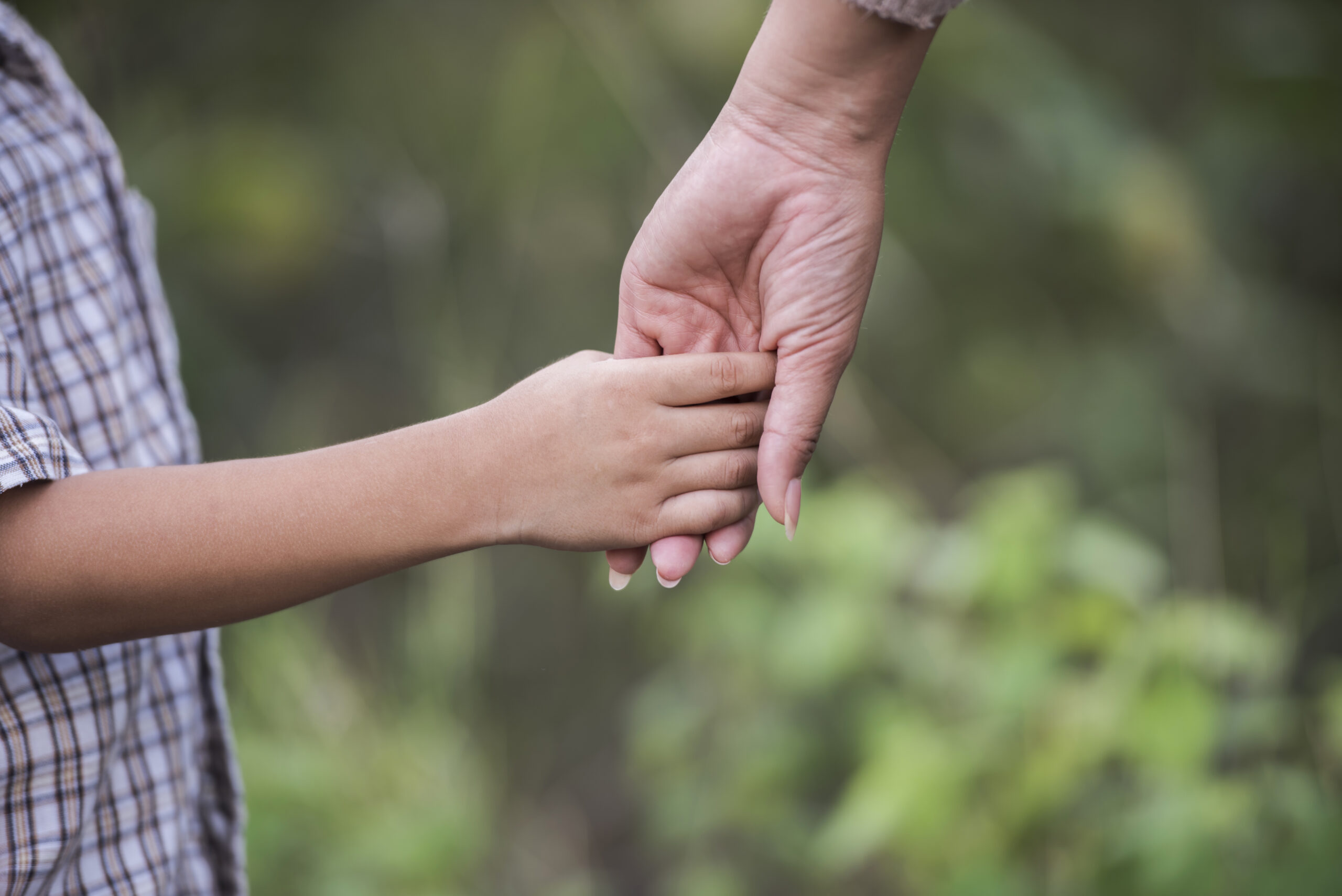 close-up-happy-mum-son-holding-hand-park-family-concept-como-prevenir-desaparecimento-de-criancas-scaled.jpg