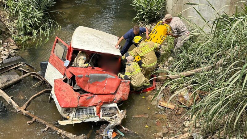Veículo desgovernado cai em rio e motorista fica preso às ferragens